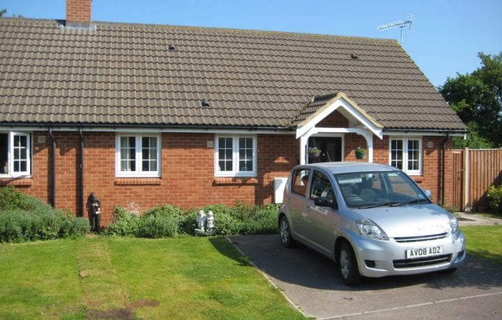 Ground Source Review: Two semi-detached bungalows share one borehole, just visible on the grass.